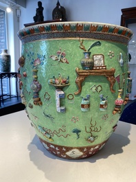 Een Chinese famille rose vissenkom met decor van antiquiteiten op een groene sgraffito fond, 19e eeuw