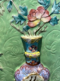 Een Chinese famille rose vissenkom met decor van antiquiteiten op een groene sgraffito fond, 19e eeuw