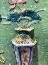 Een Chinese famille rose vissenkom met decor van antiquiteiten op een groene sgraffito fond, 19e eeuw