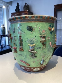 Een Chinese famille rose vissenkom met decor van antiquiteiten op een groene sgraffito fond, 19e eeuw