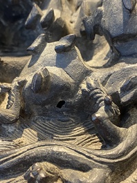 A large Chinese bronze censer and cover with a dragon in a rocky landscape with various animals, Yuan