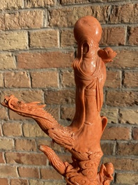 A Chinese red coral figure of a standing Bodhisattva with two dragons, 19/20th C.