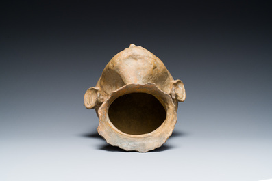 A terracotta lid fragment in the shape of a head, Southeast Asia, probably 19th C.