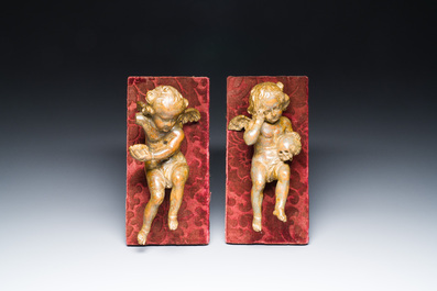 A pair of Flemish allegorical carved wood angels holding a Vanitas skull (Death) and a shell-shaped bowl (Life), 17th C.