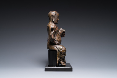 A Chinese lacquered and polychromed wood sculpture of a Buddhist guardian, Ming