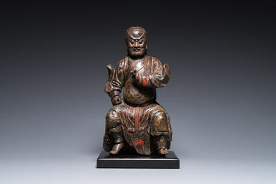 A Chinese lacquered and polychromed wood sculpture of a Buddhist guardian, Ming