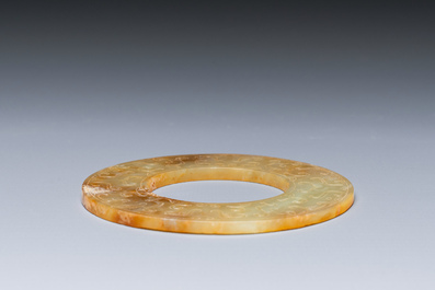 A Chinese celadon and russet jade 'bi' disc, probably Han