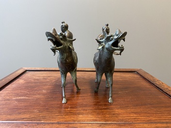 Een paar Chinese bronzen wierookbranders in de vorm van jongens op kylins, Ming