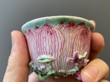 A pair of Chinese relief-decorated famille rose 'lotus' cups and saucers with a scholar and his servant, Yongzheng