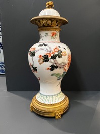 A Chinese famille verte vase and an enamelled Yixing stoneware vase with gilt bronze mounts, 19th C.