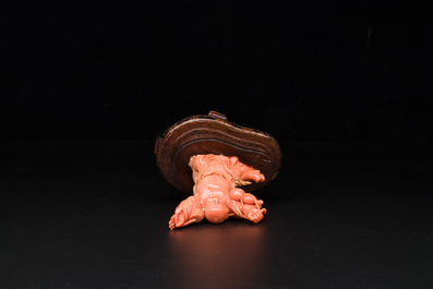 A Chinese red coral figure of a laughing Buddha on wooden stand, 19/20th C.