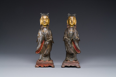 A pair of Chinese partly lacquered and gilt bronze figures of female attendants, Ming