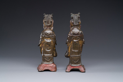 A pair of Chinese partly lacquered and gilt bronze figures of female attendants, Ming