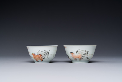 A pair of Chinese grisaille and iron-red 'buffalo' cups and saucers and a 'rooster' saucer, Yongzheng