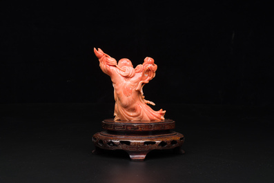 A Chinese red coral figure of a laughing Buddha on wooden stand, 19/20th C.