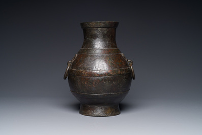 Vase de forme 'hu' en bronze aux anses en forme de taotie dans le style de Han sur socle en bois, Chine, Ming