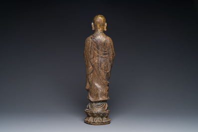 A Chinese gilt cast iron figure of a standing monk, Ming