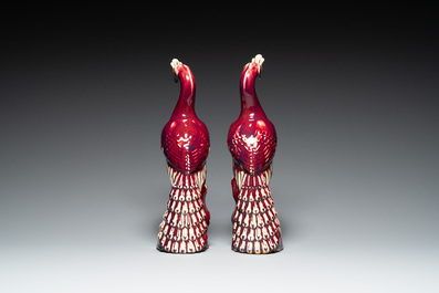 A pair of Chinese flamb&eacute;-glazed models of peacocks on wooden stands, 19th C.