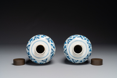 A pair of Dutch Delft blue and white chinoiserie vases with wooden covers, 18th C.