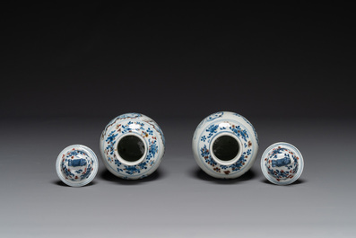 A pair of Chinese blue, white and copper-red vases and covers, Kangxi mark, 19th C.