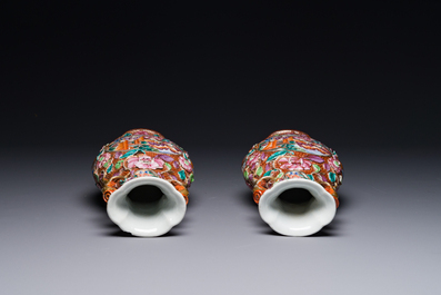 A pair of Chinese Canton famille rose 'mandarin subject' vases with floral relief design, Qianlong