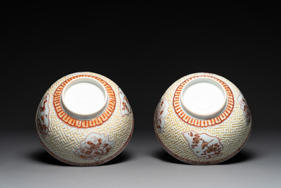 A pair of Chinese iron-red-decorated and gilt bowls with relief design, Kangxi