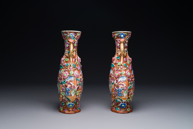 A pair of Chinese Canton famille rose 'mandarin subject' vases with floral relief design, Qianlong