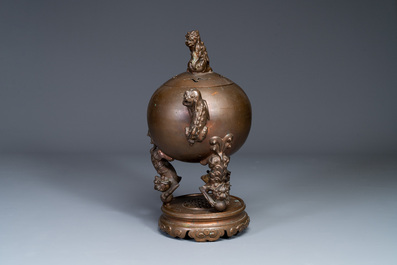 A large Chinese bronze censer and cover on stand decorated with six lions, 19th C.