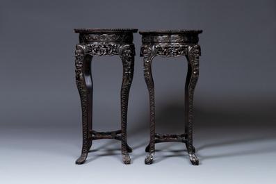 A pair of tall Chinese carved wooden stands with marble tops, 19th C.