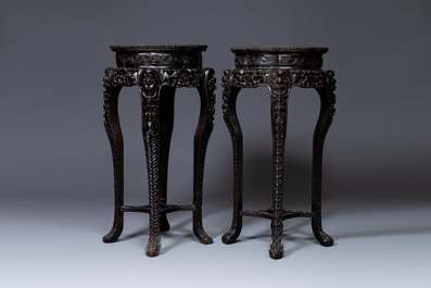 A pair of tall Chinese carved wooden stands with marble tops, 19th C.