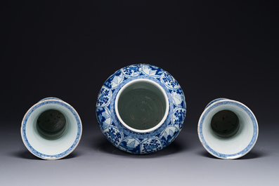 A Chinese blue and white garniture of three vases with floral and landscape design, Kangxi