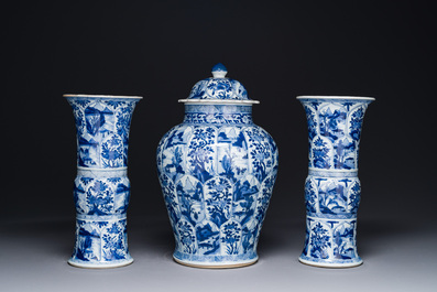 Een Chinees blauw-wit kaststel met drie vazen met floraal en landschapsdecor, Kangxi
