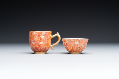 Deux rares tasses et une soucoupe en porcelaine de Chine en rouge de fer et dor&eacute; &agrave; d&eacute;cor de sc&egrave;ne europ&eacute;enne, Qianlong
