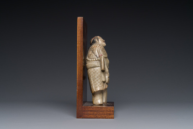 A Chinese partly polychromed soapstone figure on a wooden stand, 18th C.