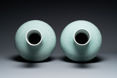 A pair of large Chinese monochrome celadon-glazed anhua 'lotus scroll' bottle vases, 19th C.