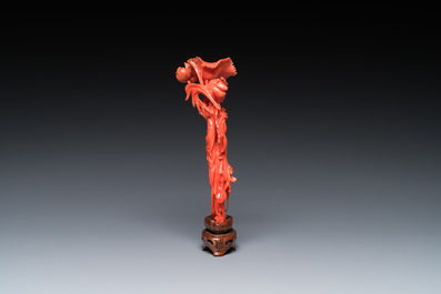 A Chinese red coral figure of a standing lady holding a flower, 19/20th C.