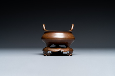 Een Chinees bronzen wierookvat met drie poten op een sokkel, Xuande merk, 19e eeuw