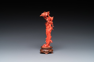 A Chinese red coral figure of a standing lady holding a flower, 19/20th C.