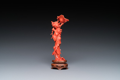 A Chinese red coral figure of a standing lady holding a flower, 19/20th C.