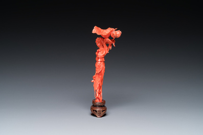 A Chinese red coral figure of a standing lady holding a flower, 19/20th C.