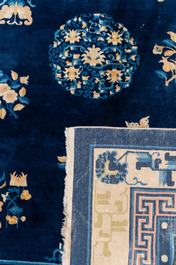 A large Chinese dark-blue-ground carpet with flowers and butterflies, 19/20th century