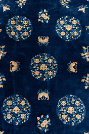 A large Chinese dark-blue-ground carpet with flowers and butterflies, 19/20th century