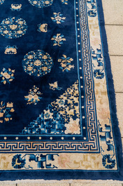 A large Chinese dark-blue-ground carpet with flowers and butterflies, 19/20th century