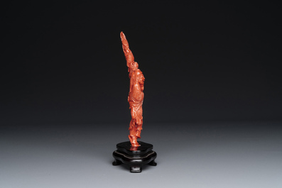 A Chinese red coral figure of a fisherman on wooden stand, 19/20th C.