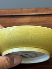 A pair of Chinese monochrome yellow-glazed saucers with incised designs of pine and cranes, Yongzheng mark and of the period