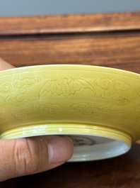 Een paar Chinese monochrome geel geglazuurde schotels met anhua decor van pijnbomen en kraanvogels, Yongzheng merk en periode