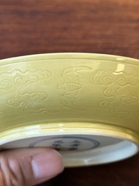 A pair of Chinese monochrome yellow-glazed saucers with incised designs of pine and cranes, Yongzheng mark and of the period