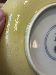A pair of Chinese monochrome yellow-glazed saucers with incised designs of pine and cranes, Yongzheng mark and of the period