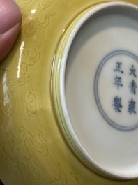 A pair of Chinese monochrome yellow-glazed saucers with incised designs of pine and cranes, Yongzheng mark and of the period