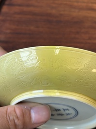 A pair of Chinese monochrome yellow-glazed saucers with incised designs of pine and cranes, Yongzheng mark and of the period